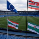 Estádio de futebol no Brasil com bandeiras do Cruzeiro e São Paulo, representando final da Copinha após 19 anos.