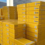 Caixas de vacinas contra febre amarela em armazém de Brasília, representando entrega do Ministério da Saúde ao Distrito Federal.