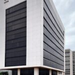 Edifício da Caesb em Brasília com elementos de atraso em resultados de concurso, estilo fotojornalístico.