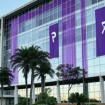 Prédio da Sefami-DF em Brasília com símbolos roxos de combate à violência doméstica, para programa de voluntários.