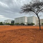 Rua em Brasília com pouca arborização, expondo falhas na política ambiental e desigualdades no DF.