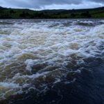 Reservatório do Descoberto transbordando no Distrito Federal, com risco de inundações na paisagem brasileira.