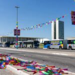 Ônibus do transporte público em Brasília durante o Carnaval, com confetes e avenida larga, representando acessos gratuitos no DF.