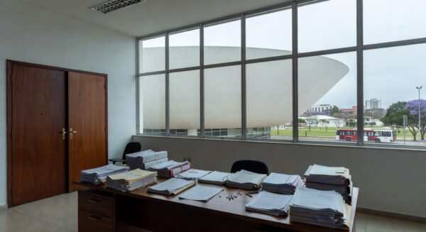 Edifício governamental em Brasília com formulários de inscrição, relógio e barreiras simbólicas para conselho da Caesb e Adasa.