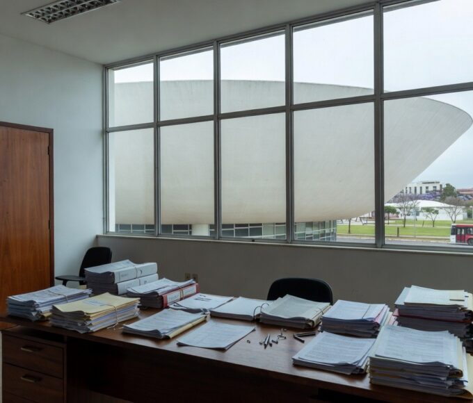 Edifício governamental em Brasília com formulários de inscrição, relógio e barreiras simbólicas para conselho da Caesb e Adasa.