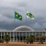 Edifício da CLDF em Brasília com símbolos de impunidade na violência contra mulheres e falhas na reintegração de policiais.