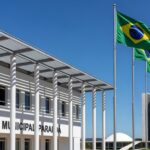 Escola pública em Brasília com Congresso Nacional ao fundo, representando acordo entre SEEDF e Senado para Oficina Legislativa.