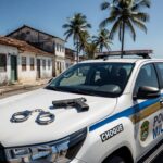 Viatura da Polícia Militar em rua de São Sebastião com algemas e arma apreendida, representando detenção por ameaça e porte ilegal.