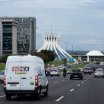 Edifício governamental em Brasília com documentos de escrituras, representando regularizações no DF.