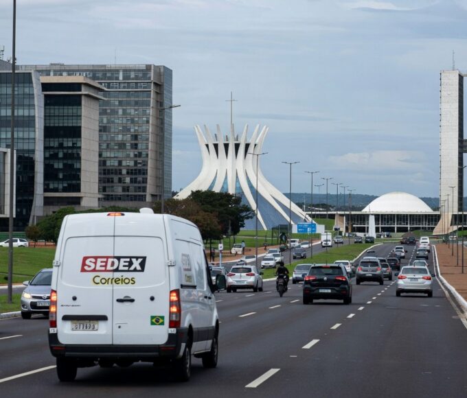 Edifício governamental em Brasília com documentos de escrituras, representando regularizações no DF.