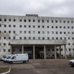 Hospital público em Brasília com sinais de negligência, fachada deteriorada e equipamentos abandonados, destacando crise na saúde do DF.