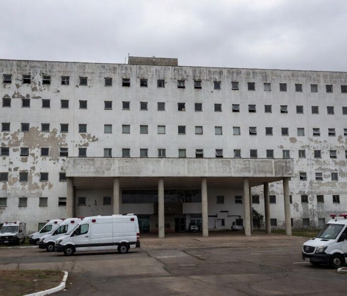 Hospital público em Brasília com sinais de negligência, fachada deteriorada e equipamentos abandonados, destacando crise na saúde do DF.