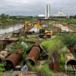 Rua em Brasília com vazamento de esgoto e falhas no saneamento, criticadas na Caesb aos 57 anos.
