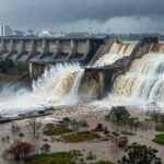 Barragem de Santa Maria transbordando no DF, com água fluindo e riscos de inundações evidentes.