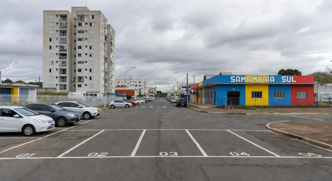 Cena de crime em vaga de estacionamento em rua de Samambaia, com fita policial e viaturas da PMDF.