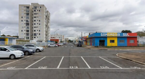 Cena de crime em vaga de estacionamento em rua de Samambaia, com fita policial e viaturas da PMDF.