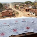 Documentos de regularização fundiária do GDF em mesa com paisagem de Planaltina ao fundo.